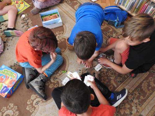 Dzieci na dywanie grają w gry planszowe